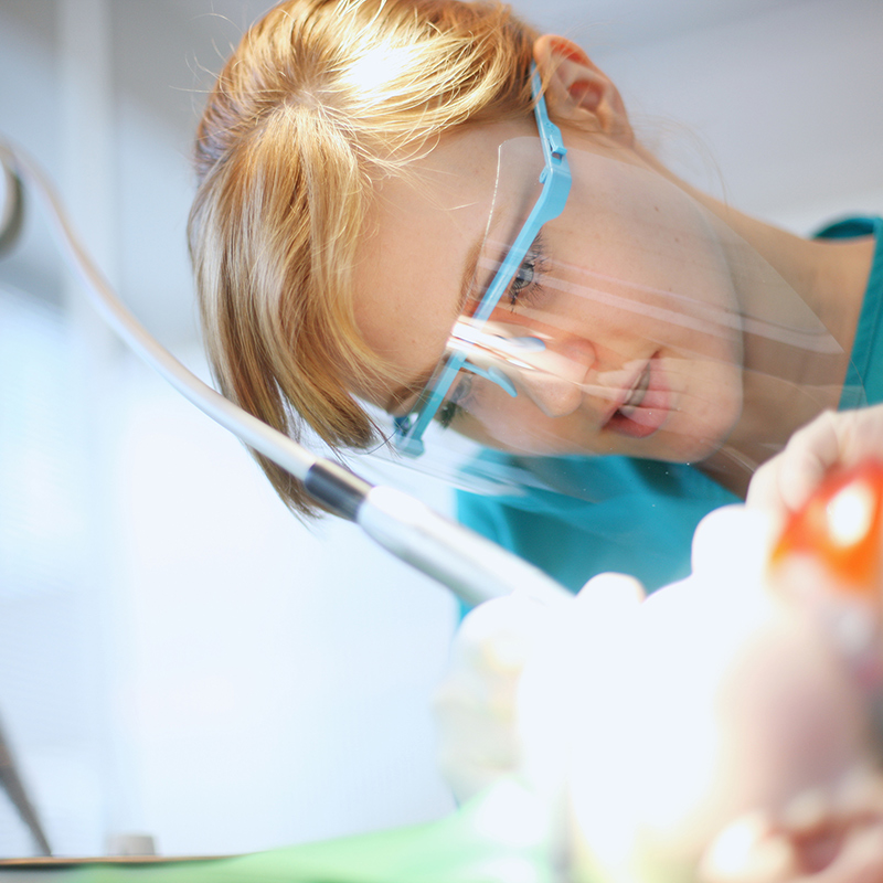 An image of a dentist performing a dental procedure